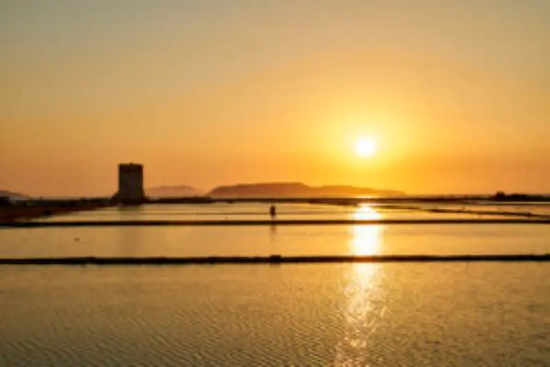 tramonto nelle saline di trapani  con vista egadi e torre di nubia